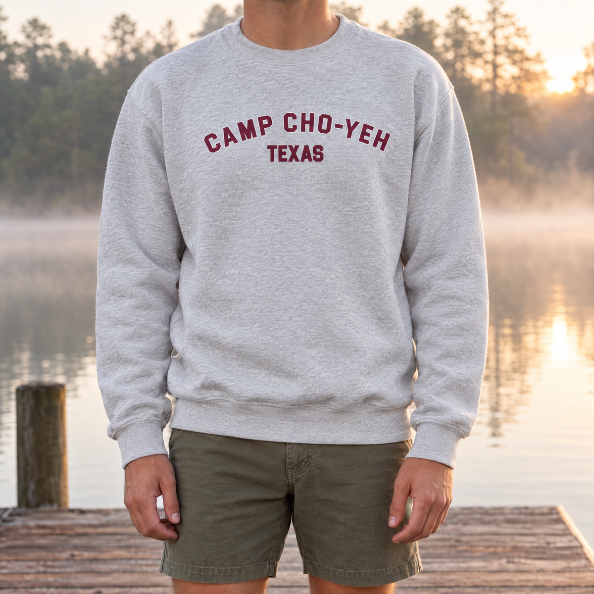 Camp Cho-Yeh Texas Crewneck in Ash, front print, worn on the dock on a misty morning at Camp Cho-Yeh
